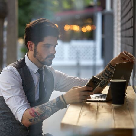 Young handsome man sitting and working on laptopの写真素材