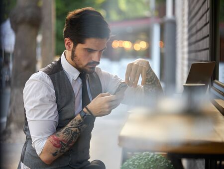 Handsome businessman making a phone call or using a phone outsideの写真素材