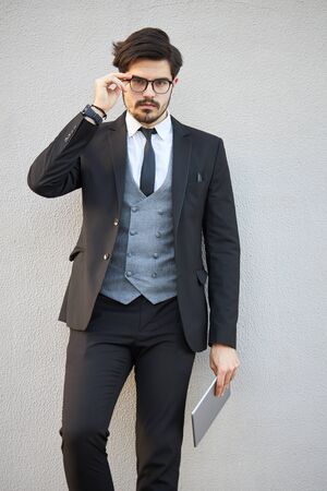 Young Businessman using a tablet pc outside wearing a classic suitの写真素材