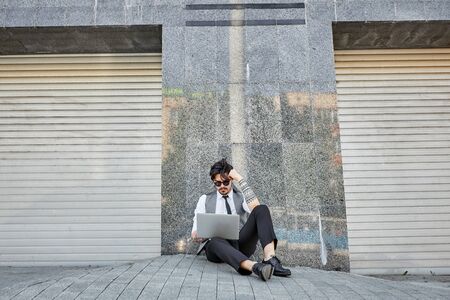 Young handsome man sitting and working on laptopの写真素材