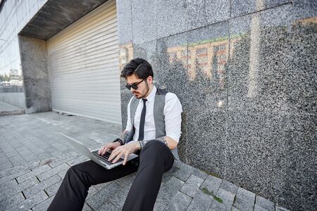 Young handsome man sitting and working on laptopの写真素材