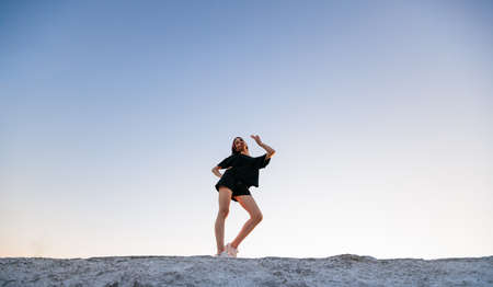 Sexy woman with a make up wearing black clothes outside at sunset. Featuring beautiful long legsの写真素材