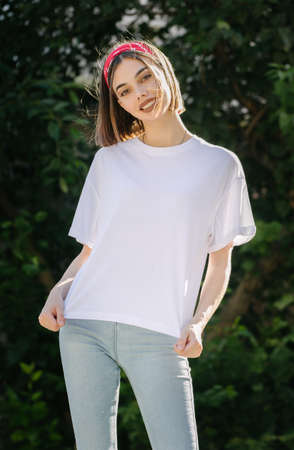 Woman or girl wearing white blank t-shirt with space for your logo, mock up or design in casual urban styleの写真素材