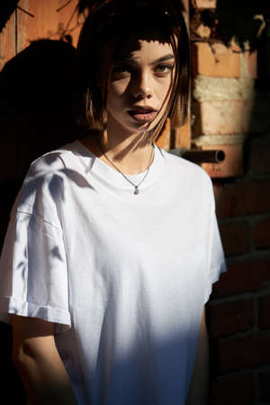 Woman or girl wearing white blank t-shirt with space for your logo, mock up or design in casual urban styleの写真素材