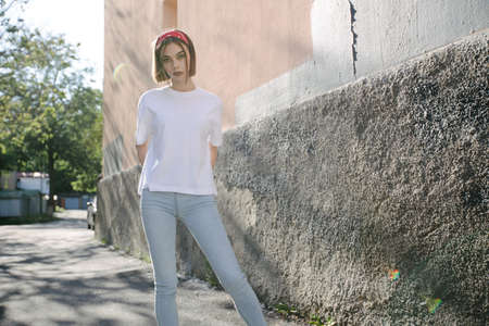 Woman or girl wearing white blank t-shirt with space for your logo, mock up or design in casual urban styleの写真素材