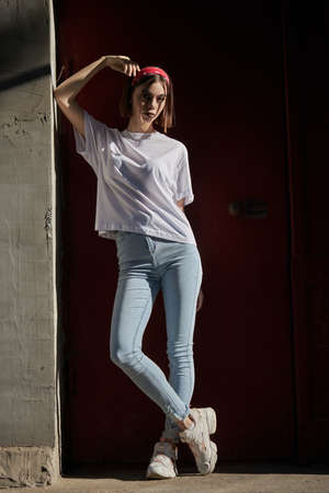 Sexy girl portrait wearing jeans jeans and white t-shirt over old wall background.の写真素材