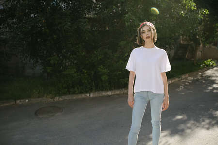 Woman or girl wearing white blank t-shirt with space for your logo, mock up or design in casual urban styleの写真素材