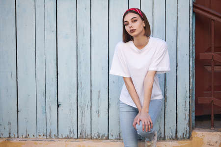 Woman or girl wearing white blank t-shirt with space, mock up or design in casual urban styleの写真素材