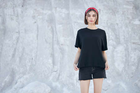 Sexy woman or girl wearing black blank t-shirt with space, mock up or design outdoorsの写真素材