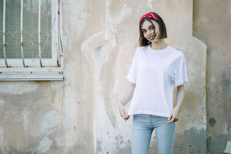 Woman or girl wearing white blank t-shirt with space, mock up or design in casual urban styleの写真素材