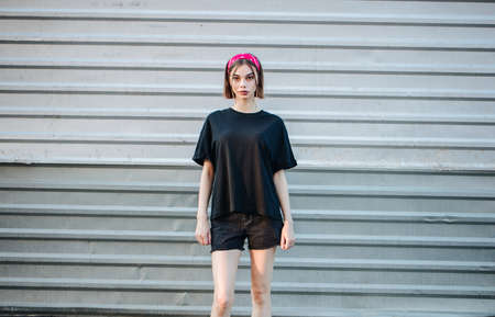 Sexy woman or girl wearing black blank t-shirt with space for your logo, mock up or design in casual urban styleの写真素材