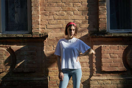Sexy girl portrait wearing jeans jeans and white t-shirt over old wall background.の写真素材