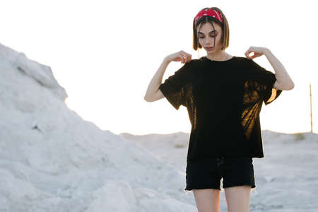 Sexy woman or girl wearing black blank t-shirt with space for your logo, mock up or design outdoorsの写真素材
