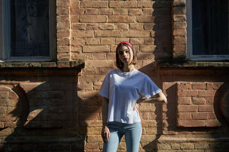 Sexy girl portrait wearing jeans jeans and white t-shirt over old wall background.の写真素材