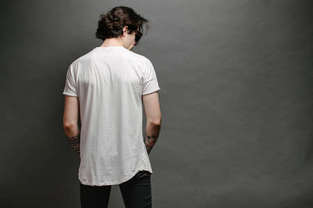 Hipster handsome male model with beard wearing white blank t-shirt and a baseball cap with space for your  designの写真素材