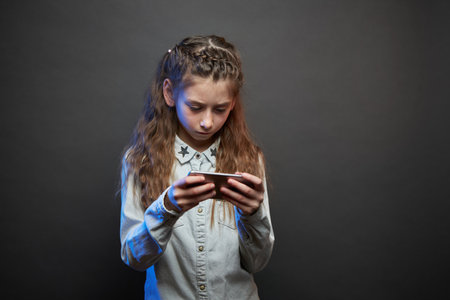 Child girl playing with a phoneの写真素材