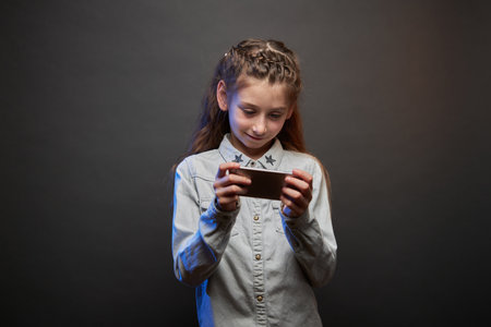 Child girl playing with a phoneの写真素材