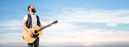 Singer and guitar player singing at sunsetの写真素材