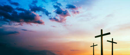 Easter concept. Cross of Jesus Christ empty over dramatic sunrise sky panorama with sclouds.の写真素材