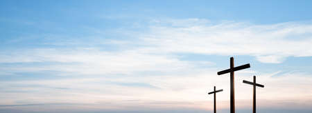 Easter concept. Cross of Jesus Christ empty over dramatic sunrise sky panorama with sclouds.の写真素材
