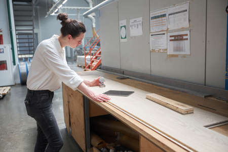 Business woman worker in the carpentry factory using tablet pc. Carpentry factory. Factory for the...