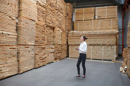 Business woman in the carpentry factory using tablet pc. Carpentry factory. Factory for the...