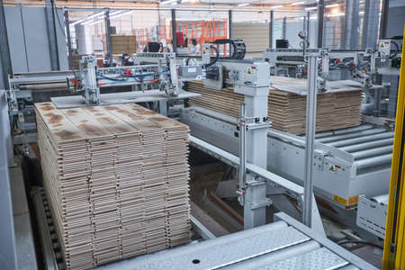 Carpentry factory. Automated equipment for laminate production. Modern robotic factory indoors. Woodworking productionの写真素材