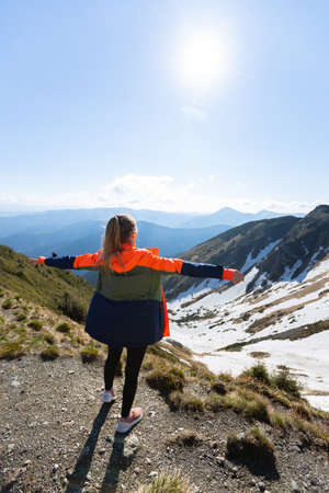 Woman hiker enjoying high peak view on mountains in summerの写真素材