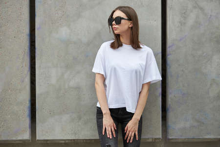 Girl or woman wearing white blank t-shirt with space for your logo, mock up or design in casual...