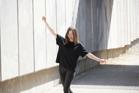 Woman or girl wearing black blank cotton t-shirt with space for your logo, mock up or design in casual urban styleの写真素材