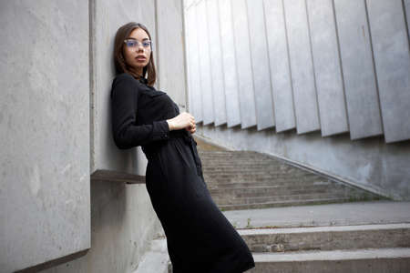 Fashion portrait of a sexy brunette woman with a make up wearing black clothes. She is wearing black...