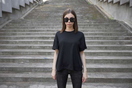 Woman or girl wearing black blank cotton t-shirt with space for your logo, mock up or design in casual urban styleの写真素材