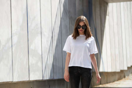 Girl or woman wearing white blank t-shirt with space for your logo, mock up or design in casual urban styleの写真素材