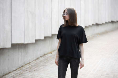 Woman or girl wearing black blank cotton t-shirt with space for your logo, mock up or design in casual urban styleの写真素材