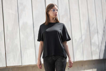 Woman or girl wearing black blank cotton t-shirt with space for your logo, mock up or design in casual urban styleの写真素材