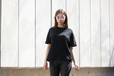 Woman or girl wearing black blank cotton t-shirt with space for your logo, mock up or design in casual urban styleの写真素材