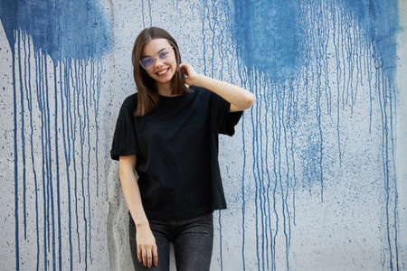 Woman or girl wearing black blank cotton t-shirt with space for your logo, mock up or design in casual urban styleの写真素材