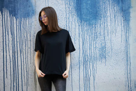 Woman or girl wearing black blank cotton t-shirt with space for your logo, mock up or design in casual urban styleの写真素材