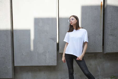 Girl or woman wearing white blank t-shirt with space for your logo, mock up or design in casual urban styleの写真素材
