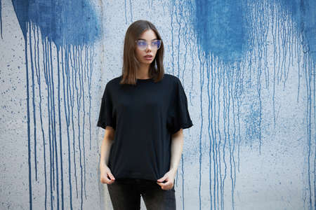 Woman or girl wearing black blank cotton t-shirt with space for your logo, mock up or design in casual urban styleの写真素材