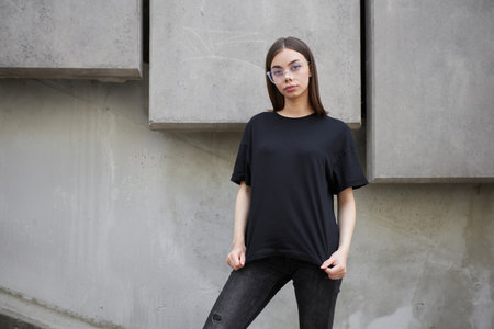 Woman or girl wearing black blank cotton t-shirt with space for your logo, mock up or design in casual urban styleの写真素材