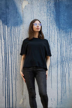 Woman or girl wearing black blank cotton t-shirt with space for your logo, mock up or design in casual urban styleの写真素材