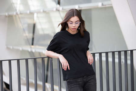Woman or girl wearing black blank cotton t-shirt with space for your logo, mock up or design in casual urban styleの写真素材