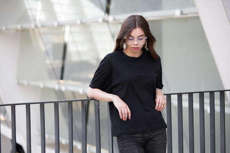 Woman or girl wearing black blank cotton t-shirt with space for your logo, mock up or design in casual urban styleの写真素材