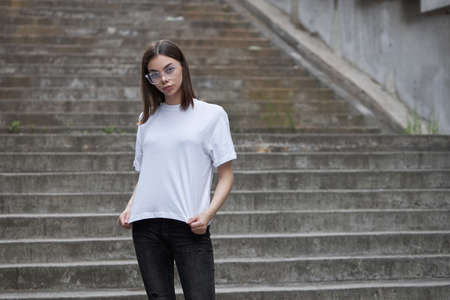 Girl or woman wearing white blank t-shirt with space for your logo, mock up or design in casual urban styleの写真素材