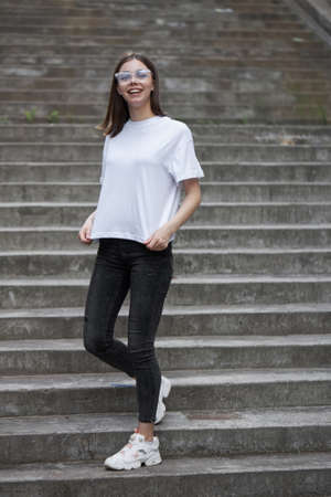 Girl or woman wearing white blank t-shirt with space for your logo, mock up or design in casual urban styleの写真素材