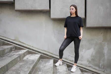 Woman or girl wearing black blank cotton t-shirt with space for your logo, mock up or design in casual urban styleの写真素材