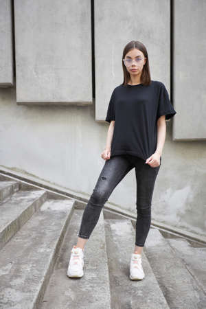 Woman or girl wearing black blank cotton t-shirt with space for your logo, mock up or design in casual urban styleの写真素材