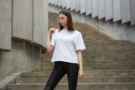 Girl or woman wearing white blank t-shirt with space for your logo, mock up or design in casual urban styleの写真素材