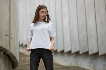 Girl or woman wearing white blank t-shirt with space for your logo, mock up or design in casual urban styleの写真素材